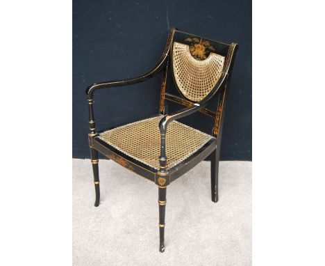 Regency style black lacquered bergere armchair with caned back and seat, open arms and raised on ring turned legs, 51cm wide 