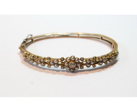 Edwardian gold hinged bangle with scrolls of pearls and old-cut diamond brilliant on triple band, probably 9ct, 12g. Conditio