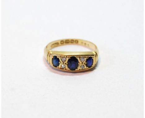 Sapphire and diamond three-stone ring with four small brilliants, 18ct gold, 1924, size N, 3g.