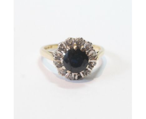 Diamond and sapphire circular cluster ring in 18ct gold, 1970, size L.