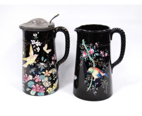 Two Dudson Pottery Jet Ware (Ebony) jugs with polychrome enamel decoration of birds and butterflies amongst flowers and folia