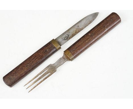 An antique campaign knife and fork set with wooden handles and brass fittings. 