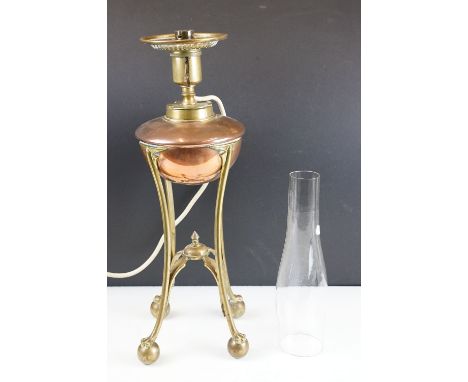 W.A.S. Benson Arts &amp; Craft oil lamp, with a copper font over a brass tri-form base with paw &amp; ball feet, stamped Ever