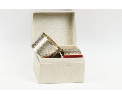 A pair of fully hallmarked sterling silver napkin rings with engine turned decoration, Birmingham 1944, within original displ