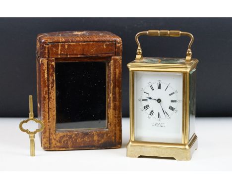 An antique French brass cased carriage clock with beveled glass panels, repeater button to top, retailer marked for P. Orr &a