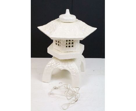 White ceramic table lamp modelled as a pagoda, with lustre finish, raised on four legs, measures approx 56cm tall 
