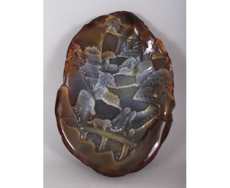 A CHINESE AGATE BOULDER, carved with a scene of two sages crossing a bridge in the company of a dog in a mountainous landscap