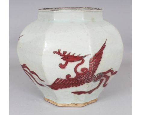 A CHINESE YUAN STYLE COPPER-RED OCTAGONAL SECTION PORCELAIN PHOENIX JAR, the base unglazed, 9.5in wide & 9in high.