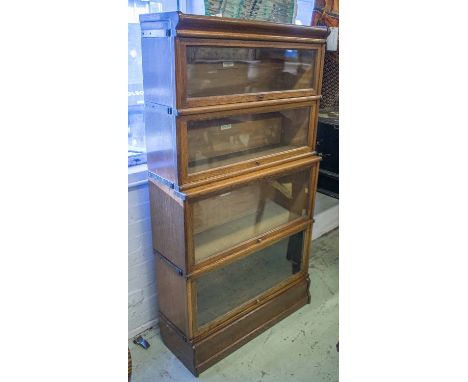 GLOBE WERNICKE BOOKCASE, early 20th century oak in graduated sections with four glazed doors, 156cm H x 87cm x 33cm.