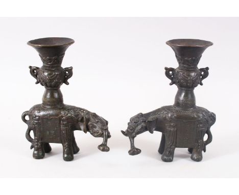 A GOOD PAIR OF 19TH CENTURY CHINESE BRONZE ELEPHANT CANDLESTICKS, the mirrored pair with miniature vases upon their backs to 