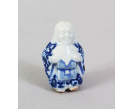 A JAPANESE MEIJI PERIOD BLUE &amp; WHITE PORCELAIN NETSUKE OF SHOJO, stood holding a fan in her hands, artist signed to the r
