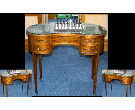 An Edwardian Kidney Shaped Writing Desk complete with a green leather inset top. Central frieze drawer between four further s