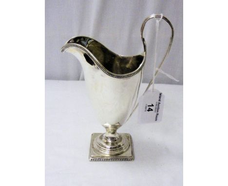 A Georgian style silver helmet shaped cream jug on square base