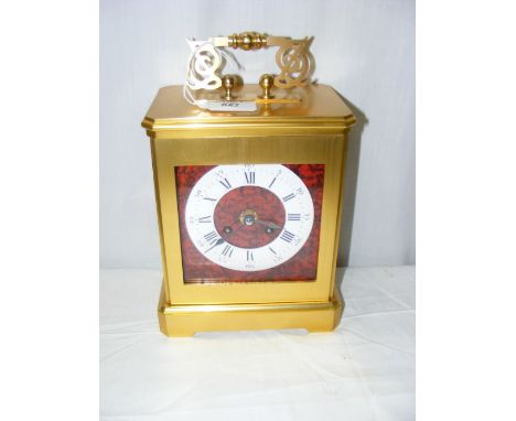 A large brass cased and simulated red boulle striking mantel clock with enamel chapter ring and Roman numerals striking on be