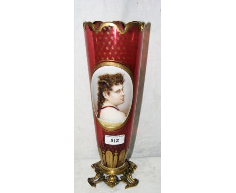 A 33cm high gilt decorated cranberry glass vase with hand-painted oval portrait panel to the centre on cast ormolu base