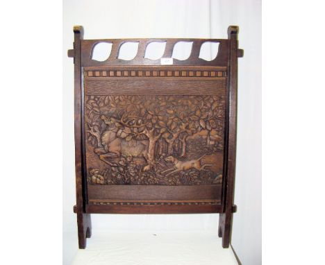 An art nouveau oak fire screen, the centre panel depicting woodland scene with stag being chased by a dog and bearing the Lea