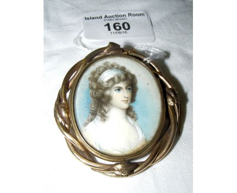 An early 19th century oval portrait miniature in ornate pinchbeck brooch mount