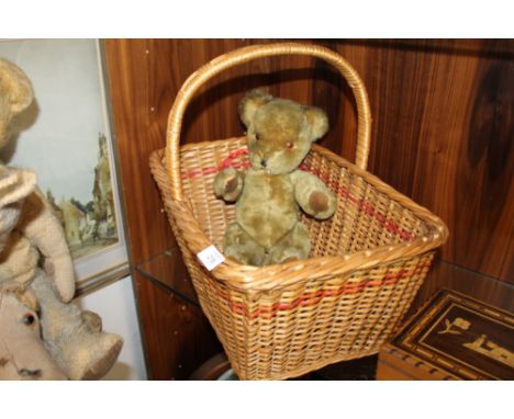 A VINTAGE PEDIGREE HUG ME BEAR WITH BELL EARS IN A WICKER BASKET