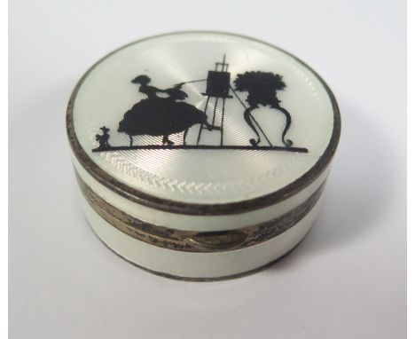 A Sterling Silver and Guilloché Enamel Patch Box decorated with a silhouette of a seated lady painting at an easel, London 19
