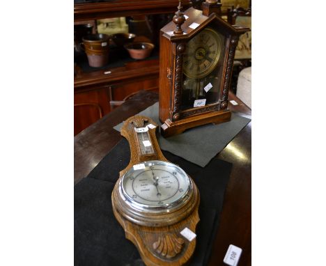 An early 20th century oak aneroid barometer; a mahogany cased American mantel alarm clock (2)