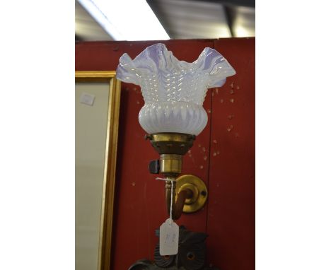 A brass swan neck wall light, ornate Vaseline glass shade