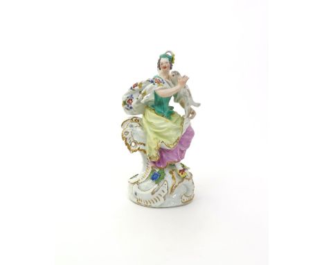 A Meissen model of a lady with a dog  c.1760-70, seated on tall scrollwork heightened in gilt, the small dog standing on her 