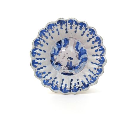 An early Brislington delftware lobed dish  c.1680, the well painted in blue and manganese with a seated figure, the fluted ri