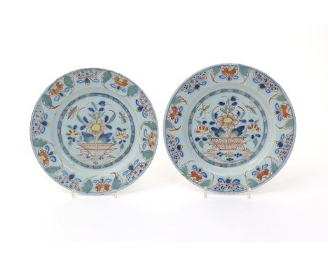 A pair of English delftware plates  c.1760, painted in a palette of red, green, yellow and blue with flying insects above flo
