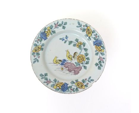 An English delftware plate  mid 18th century, well painted with a Chinese design of a crowing cockerel perched atop rockwork 
