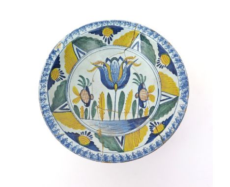 A delftware tulip charger  c.1730-40, probably Brislington, brightly decorated in blue, green, yellow and ochre, with a large