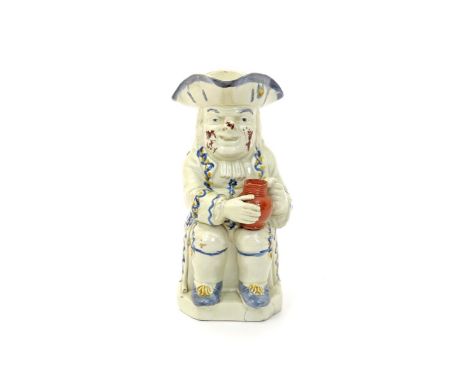 A creamware Toby jug  c.1790, seated with a terracotta-coloured empty jug on his left knee, a long-stemmed clay pipe resting 