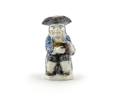 A Wood-type pearlware Toby jug  c.1790, modelled in typical seated pose with foaming jug of ale, a small upright barrel betwe