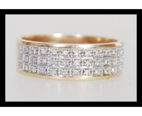 A hallmarked 9ct gold diamond band ring of wide form having three rows of in set diamonds. Weighs 3.6 grams size T.