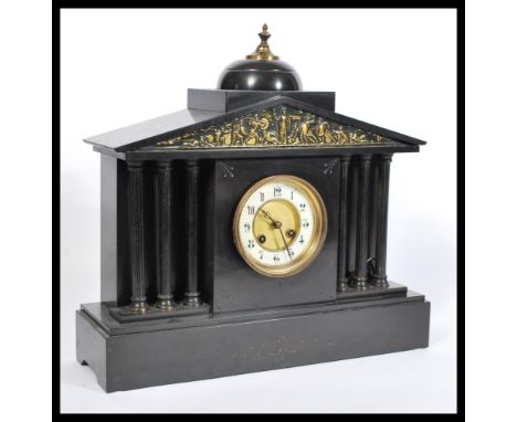 A Victorian 19th century slate and marble mantel clock. Raised on a plinth base with barrel dial and spire top. The 8 day mov