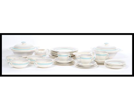 A vintage retro Clarice Cliff part tea / dinner service having blue stripes and gilt detailing comprising of tea cups, saucer