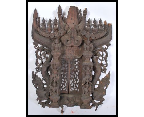 An unusual large Tibetan - Chinese hardwood architectural panel depicting dragons and deity characters surmounted by floral r