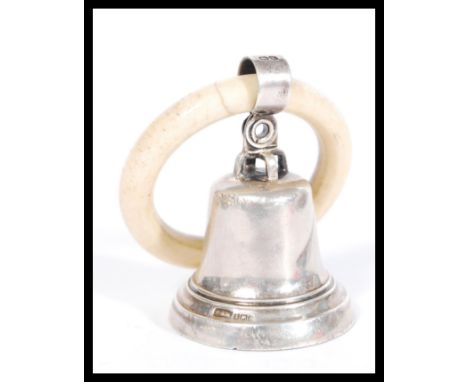 An early 20th Century silver hallmarked childs rattle in the form of a bell on a teething ring. Hallmarked Birmingham 1921. M