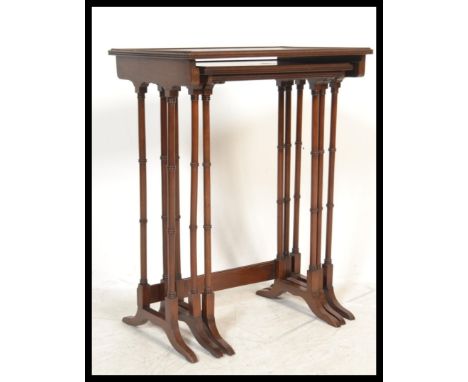 An Edwardian mahogany nest of tables being raised on ring turned legs in the form of bamboo set on splayed legs, each table w