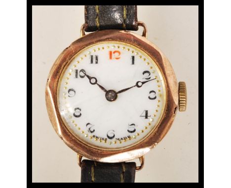 A hallmarked 9ct gold wrist watch having a white enamel face with gilt surrounded chapter ring and faceted hands. Set to a vi