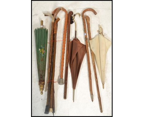 A collection of vintage walking sticks canes from the 20th Century together with a stunning silk parasol with the handle mode