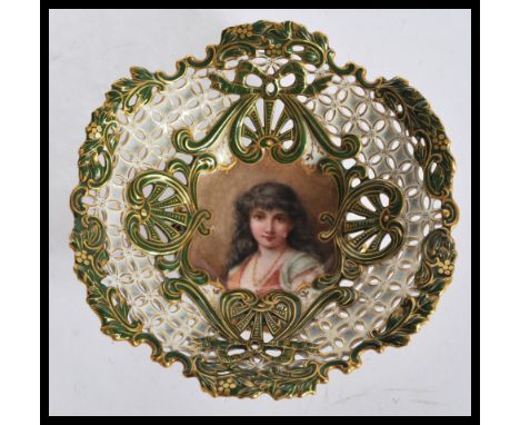 An early 20th Century Coalport fret pierced tazza bowl having a hand painted portrait of a lady to centre with green and gilt