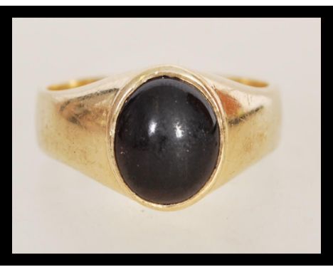 A hallmarked 9ct gold signet ring of large form having a deep red agate stone in oval setting. Weighs 10.3 grams size Z.5.