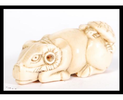 A rare and unusual 19th century Meiji period ivory Netsuke of a crouching / seated ox with tortoise on its back. Signed to th