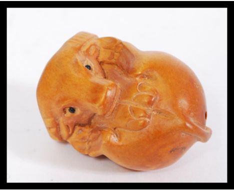 A 20th century Japanese carved wooden netsuke in the form of a bison with signature present. Measures 4cm high.&nbsp;