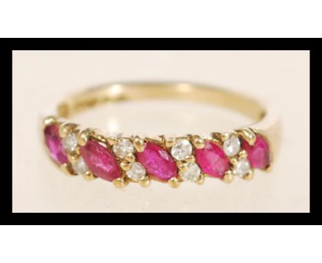 A hallmarked 9ct gold ruby and diamond ring set with alternating marquise cut rubies and round cut diamonds. Total weight 1.8