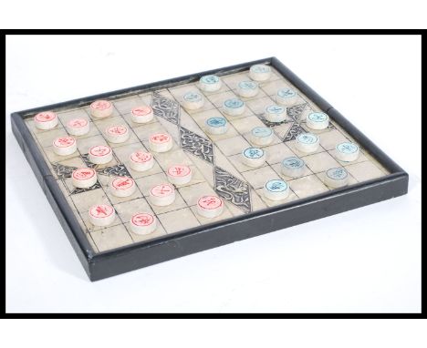 A 20th century Chinese checkers board game having stone counters gaming pieces having calligraphy lettering contained within 