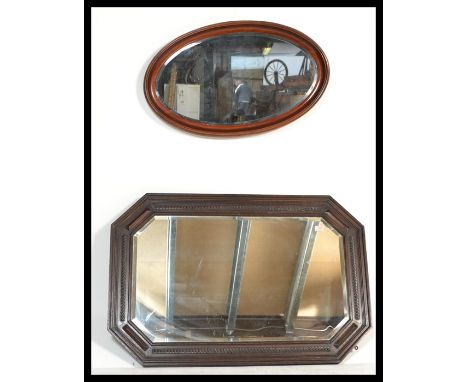 Two vintage early 20th Century Edwardian wall hanging mirrors, the first or rectangular form having a large carved oak frame 