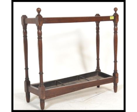 A Victorian 19th century mahogany stick stand in the manner of Shoolbred, London. Raised on turned columns supports having fi