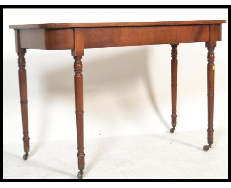 A Georgian 19th century mahogany console hall table being raised&nbsp; on turned tapering legs with fitted frieze and flared 