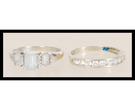 Two stamped 9ct white gold rings to include a ring channel set with round white stones (size R.5), and a ring set with three 